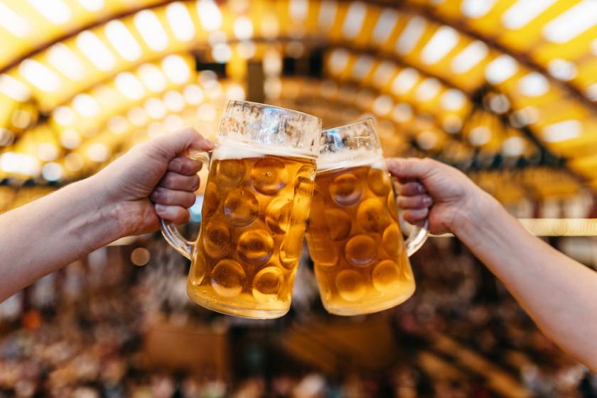 Two people clinking beer mugs