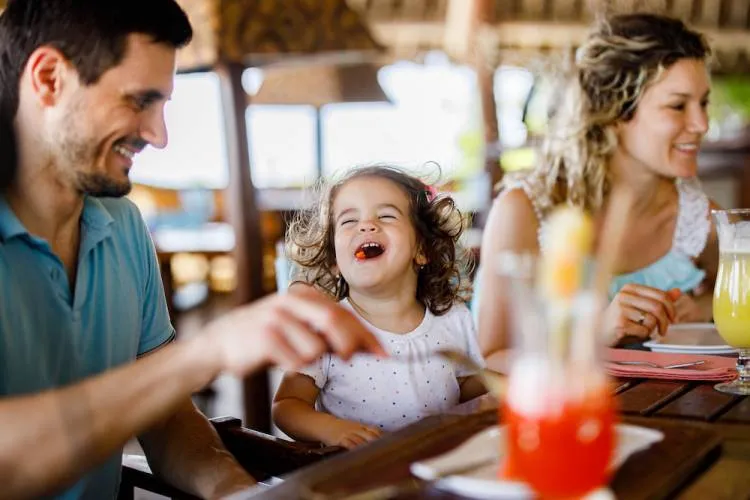 Family eating dinner together laughing